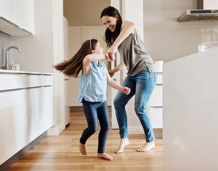 adorable little girl dancing with her mother at home
