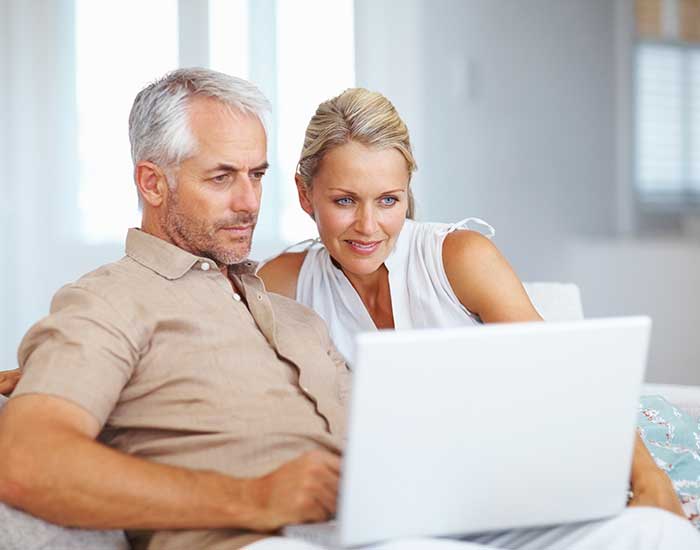 Mature couple using laptop at home